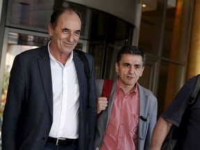 Greek Economy Minister George Stathakis (L) and Finance Minister Euclid Tsakalotos leave a hotel following an overnight meeting with representatives of the International Monetary Fund, the European Commission, the European Central Bank and the eurozone's rescue fund, the European Stability Mechanism in Athens, August 11, 2015. Greece and its international lenders clinched a multi-billion-euro bailout agreement on Tuesday after marathon talks through the night, officials said, raising hopes aid can be disbursed in time for a major debt repayment falling due in days.  REUTERS/Alkis Konstantinidis