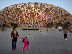 In this March 28, 2015 file photo, of a girl as she flies a kite on Olympic Green near Beijing National Stadium, also known as the Birds Nest. (AP Photo/Mark Schiefelbein, File)