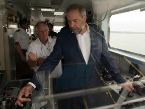 Federal New Democratic Party leader Thomas Mulcair  tries his hand at navigating the ferry to Sorel Tuesday, August 11, 2015  in St. Ignace-de-Loyola, Que. THE CANADIAN PRESS/Ryan Remiorz