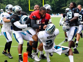Carolina Panthers' Cam Newton, middle, and Josh Norman, bottom, scuffle during an NFL football training camp at Wofford College, Monday, Aug. 10, 2015, in Spartanburg, S.C. (David T. Foster III/AP)