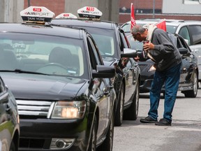 A long line of airport taxi drivers protest a new contract between the airport and Coventry Connections that would require drivers to pay $5.00 per trip for fares from the airport. Tuesday August 11, 2015. Errol McGihon/Ottawa Sun/Postmedia Network