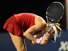 Eugenie Bouchard, of Canada, hits her racquet on the ground after being broken in the third set against Belinda Bencic, of Switzerland, during tennis action at Rogers Cup in Toronto on Tuesday, August 11, 2015. THE CANADIAN PRESS/Frank Gunn