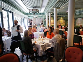 In this Nov. 21, 2014 file photo, guests sit for a tasting in the main dining room of Brennan's Restaurant, a historic restaurant in the French Quarter in New Orleans. New Orleans’ tourism industry has rebuilt, rebounded and modernized in the 10 years since Katrina, and its restaurant scene has boomed. (AP Photo/Gerald Herbert, File)
