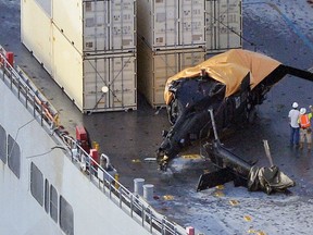 A yellow sheet covers a U.S. Army helicopter U-60 that crashed on the Navy cargo vessel USNS Red Cloud in the waters around 20 miles (30 km) east of Japan's southern island of Okinawa, on Aug. 12, 2015. (Ryosuke Uematsu/Kyodo News via AP)