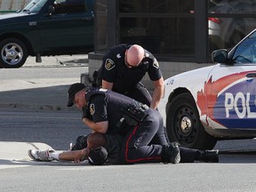 Greater Sudbury Police arrest a man outside Shoppers Drug Mart on Frood Road in Sudbury, Ont. on Tuesday August 11, 2015. John Lappa/Sudbury Star/Postmedia Network