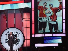 Host Rob Riggle unveils the cover of the EA Sports NHL 16 video game featuring Jonathan Toews and Patrick Kane from the Chicago Blackhawks during the 2015 NHL Awards at MGM Grand Garden Arena on June 24, 2015. (Ethan Miller/Getty Images/AFP)