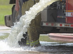 A member of the Springfeild Fire Department fills a pumper truck at Harboor View park to cool hot spots in the fire at General Scrap.  Wednesday, June 13, 2012.
