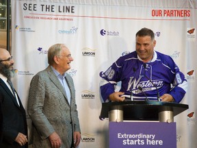 Doctors Greg Dekaban, Arthur Brown and Peter Fowler watch as Eric Lindros pulls on a Western hockey jersey at the announcement that the NHLPA is giving a seed donation of $500,000 to study concussions and brain injury at the See The Line conference in London, Ont. on Wednesday August 12, 2015. 
Fowler and Lindros made several trips to the NHLPA to get the funding while Dekaban and Brown are doing research in the field.
Mike Hensen/The London Free Press/Postmedia Network
