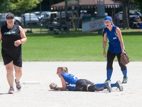 Amy Nesbitt of the Ontario Freaks, left, and Jamie Taylor and Heather Mayes of the Yukon Titans share a laugh after Taylor tagged Nesbitt out on her way to second base during the Canadian slo-pitch championships at Slo-Pitch City in Dorchester on Wednesday. The Freaks won 21-0. (DEREK RUTTAN, The London Free Press)
