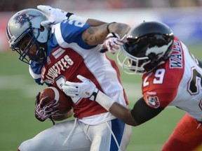 Montreal Alouettes slotback Fred Stamps (2) is tackled by Calgary Stampeders defensive back Jamar Wall (29) during first half CFL football action in Montreal, Friday July 3, 2015. THE CANADIAN PRESS/Ryan Remiorz