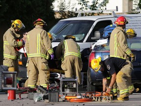 Kingston firefighters work to free a person from a car involved in a three-vehicle collision in Kingston, Ont. on Thursday, Aug 13, 2015. 
Elliot Ferguson/Kingston Whig-Standard