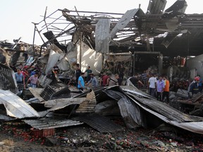 Civilians gather at the scene of a bomb attack in Jameela market in the Iraqi capital's crowded Sadr City neighbourhood Baghdad, Iraq, on Aug. 13, 2015. (AP Photo/Karim Kadim)