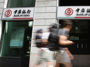 People walk past a branch of the Bank of China in downtown Milan, Italy, Thursday, Aug. 13, 2015. Global stocks are steadying as the decline in China's currency slowed and the country's central bank tried to ease fears of more big declines. (AP Photo/Antonio Calanni)
