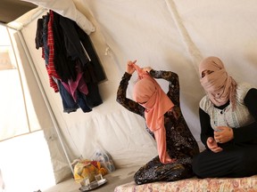 Yazidi sisters, who escaped from captivity by Islamic State (IS) militants, sit in a tent at Sharya refugee camp on the outskirts of Duhok province July 3, 2015. The sisters were among one hundred women, men and children taken by IS as prisoners after the militants attacked their village of Tal Ezayr in the northern Iraqi province of Mosul close to Syrian border last year. (REUTERS/Ari Jala)