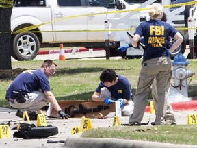 FBI investigators collect evidence, including a rifle, where two gunmen were shot dead after their bodies were removed in Garland, Texas May 4, 2015. Texas police shot dead two gunmen who opened fire on Sunday outside an exhibit of caricatures of the Prophet Mohammad that was organized by a group described as anti-Islamic and billed as a free-speech event. REUTERS/Laura Buckman