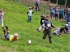 Cheese lovers tumble and run after an 11-pound wheel of Courtenay Cheddar cheese in Whistler, B.C., at the 2014 Canadian Cheese Rolling Festival in this August 15, 2014 handout photo. Cheese aficionados will be chasing a five-kilogram wheel of the dairy product down the slopes of Blackcomb Mountain on Saturday, August 15, 2015. THE CANADIAN PRESS/HO - Canadian Cheese Rolling Festival, Jeff Vinnick