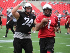 Ottawa RedBlacks defensive tackle Keith Shologan chases QB Henry Burris down in practice at TD Place on Wednesday.TIM BAINES/OTTAWA SUN