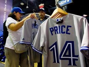 Toronto Blue Jays fans try on the jersey of pitcher David Price. (The Canadian Press/Nathan Denette)