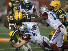 Edmonton Eskimos' Shakir Bell (33) is tackled by Montreal Alouettes' Kyler Elsworth during the second half of their CFL football game against the Edmonton Eskimos in Montreal, August 13, 2015. REUTERS/Christinne Muschi