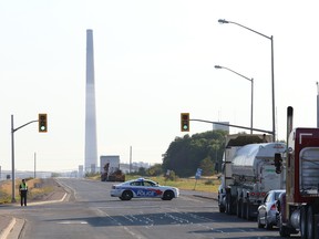 A Greater Sudbury Police officer uses a police cruiser to block Municipal Road 55 heading to Copper Cliff, Ont. following a gas leak at Vale's acid plant in Copper Cliff on Thursday, August 13, 2015. John Lappa/Sudbury Star/Postmedia Network