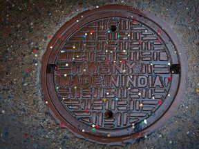 A manhole cover is covered in confetti on 6th Ave following the Macy's Thanksgiving Day Parade in New York November 27, 2014.  REUTERS/Carlo Allegri