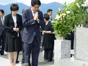 Japanese Prime Minister Shinzo Abe, accompanied by his wife Akie, left, prays at his ancestors' grave in Nagato, western Japan, Friday, Aug. 14, 2015. Later in the day Abe expressed "profound grief" for all who perished in World War II in a statement marking the 70th anniversary of the country's surrender. Abe acknowledged in the statement delivered live on national television that Japan inflicted "immeasurable damage and suffering" on innocent people in the war. He also expressed apologies for Japan's actions. (Yuta Omori/Kyodo News via AP)