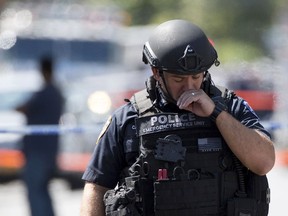 A member of the New York City Police Department Emergency Services Unit walks near the scene where Garland Tyree barricaded himself in his home after shooting a New York Fire Department lieutenant in Staten Island, New York, August 14, 2015. A firefighter was shot twice and wounded on Friday by a man wielding an assault rifle who set his home ablaze in a ongoing standoff with New York authorities to avoid being arrested, Police Commissioner Bill Bratton said. REUTERS/Andrew Kelly