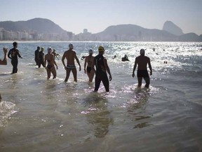 People wade into the water during a clinic held by U.S. triathletes for local swimmers along Copacabana beach in Rio de Janeiro, Brazil on Aug. 3, 2015. The head of swimming's governing body says dirty water at next year's Olympic venues is "not a big problem." An Associated Press investigation last week showed a serious health risk to the 1,400 Olympic athletes who will compete at water venues around Rio de Janeiro that are rife with human waste and sewage. THE CANADIAN PRESS/AP, Leo Correa