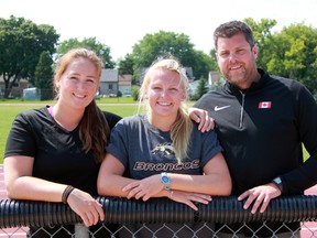 Riley Wilhelm, middle, signed a national letter of intent Tuesday to accept a scholarship and join the Western Michigan University women's track and field team this fall. The 18-year-old Sarnia native's career has been helped by Sarnia Athletics Southwest Track and Field Club coaches Maggie Mullen and Joel Skinner.  Terry Bridge/Sarnia Observer/Postmedia Network