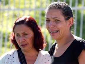Angela Pereira de Souza, whose husband was shot dead in a bar the night before, cries outside a police station in the Sao Paulo suburb Osasco, Brazil, Friday, Aug. 14, 2015. Police in Brazil's biggest city are investigating the shooting deaths of at least 17 people within the span of about three hours. According to police 10 people were shot dead in an Osasco bar after hooded men got out of a car and opened fire.  (AP Photo/Andre Penner)