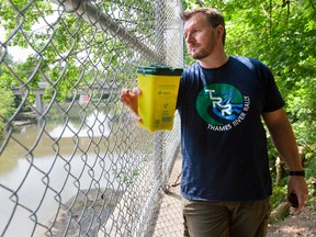 Tom Cull of the Thames River Cleanup finds unused needles stashed near a spot commonly used to shoot up drugs east of the Carfrae bridge in London. Cull says two boxes for discarded needles near the bridge are well used. (MIKE HENSEN, The London Free Press)