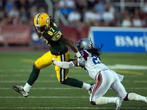 Montreal Alouettes' Jonathan Hefney (23)  tackles Edmonton Eskimos Derel Walker (87) during the first half of their CFL football game in Montreal, August 13, 2015. REUTERS/Christinne Muschi