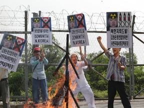 In this Aug. 11, 2015 photo, members of South Korean conservative group shout slogans after burning an effigy of North Korean leader Kim Jong Un. On Aug. 15, 2015, North Korea threatened to attack South Korean loudspeakers that are broadcasting anti-Pyongyang propaganda messages across their shared border, the world's most heavily armed. The warning follows Pyongyang's earlier denial that it had planted land mines on the South Korean side of the Demilitarized Zone that injured two South Korean soldiers last week. Seoul retaliated for those injuries by restarting the loudspeaker propaganda broadcasts for the first time in 11 years and suggested more actions could follow. The placards read: "North Korea, land mine provocation." (AP Photo/Lee Jin-man, File)