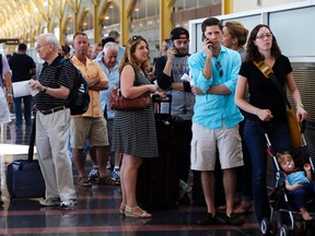 People stand in line at Washington's Reagan National Airport after technical issues at a Federal Aviation Administration center in Virginia caused delays on Saturday, Aug. 15, 2015. (AP Photo/Jacquelyn Martin)