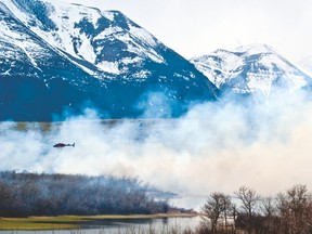 In this file photo Parks Canada helicopters fly over a controlled burn in late April 2015. Currently, Canadian firefighters are taking on a blaze south of the border in Montana. Greg Cowan photo/Pincher Creek Echo.