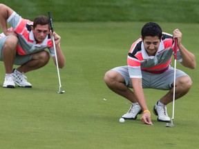 Lewis Miller (L) and playing partner Isaac Lieff line up a putt while playing in the Junior Division of the Ottawa Sun Scramble at eQuinelle Golf Club on Thursday August 21, 2014. Errol McGihon/Ottawa Sun files
