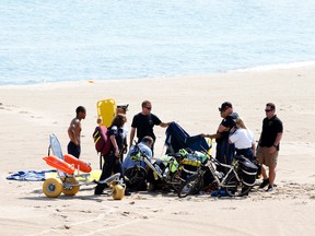 A Navy Leap Frog parachutist receives medical attention on North Avenue Beach on Saturday, Aug. 15, 2015, after a performance at the first day of the annual Chicago Air & Water Show in Chicago. (Michael Noble Jr./Chicago Tribune via AP)