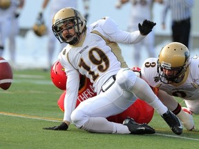 University of Manitoba Bisons Tyler Fong yells after knocking down a pass meant for University of Calgary Dinos Brendan Thera during the Hardy Cup at McMahon Stadium in Calgary, Alberta, on Nov. 9, 2013. (Mike Drew/Calgary Sun)
