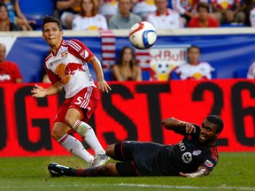 New York Red Bulls midfielder/defender Connor Lade (left) takes a shot against Toronto FC defender Ashtone Morgan during the first half at Red Bull Arena on Saturday. (USA TODAY Sports)