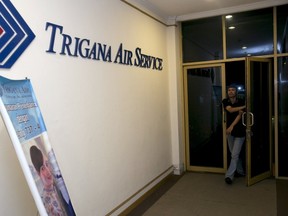 A man walks into the entrance of Trigana Air's office in Jakarta, Indonesia August 16, 2015. Villagers in Indonesia's remote and mountainous eastern Papua region reported that an aircraft had crashed, a Trigana Air official said on Sunday, several hours after an aircraft carrying 54 people went missing, media reports said.   REUTERS/Darren Whiteside