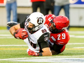 Brad Sinopoli of the Ottawa RedBlacks is wrapped up by Jamar Wall of the Calgary Stampeders during CFL action in Calgary, Alta., on Saturday, Aug. 15, 2015. Lyle Aspinall/Calgary Sun/Postmedia Network