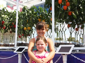 Breanna Mootrey, 8, and her cousin Kaylee Riddell, 5, both of Corunna, check out a mobile greenhouse in the Real Canadian Superstore parking lot on Sunday August 16, 2015 in Sarnia, Ont. Leamington-based NatureFresh Farms has been taking its mobile greenhouse around Canada and the U.S. this summer to educate the public about agriculture and the importance of healthy eating. (Barbara Simpson/Sarnia Observer/Postmedia Network)
