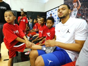 Tyler Ennis ties the shoes of his six-year-old brother, Tyylon, as they took part in a basketball clinic at the Air Canada Centre yesterday. (Michael Peake/Toronto Sun)