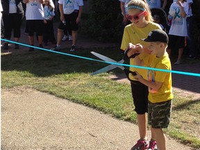 Danette Belanger’s two children cut the ribbon to start last year’s Walk of Hope. The fourth annual walk will take place in Vermilion on Sept. 13.