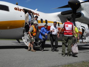 In this undated file photo, Kashechewan residents are seen disembarking at the airport in Kapuskasing after a state of emergency is declared and they were forced to evacuate due to high risk of flooding in their community.