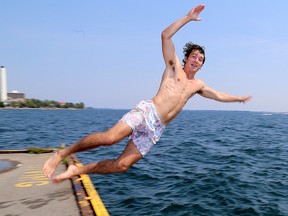 Joel Zelt takes a break from hot temperatures by jumping off the dock at the King Street West Water Purification plant in Kingston on Monday Aug. 17 2015. Ian MacAlpine/Kingston Whig-Standard/Postmedia Network.