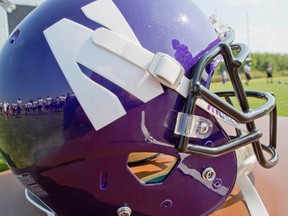 Northwestern football players are reflected in a helmet during drills at practice at the University of Wisconsin-Parkside campus on Monday, Aug. 17, 2015, in Kenosha, Wi. (AP Photo/Jeffrey Phelps)