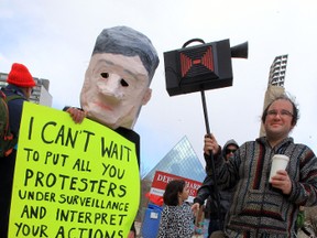 Stuart Andrews, right, carries a fake camera during a C-51 protest at Churchill Square in Edmonton, Alberta on Saturday April 18, 2015. Perry Mah/Edmonton Sun/Postmedia Network