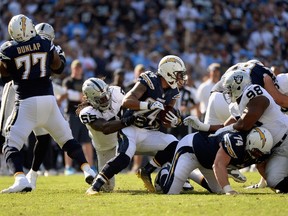 Ryan Mathews of the San Diego Chargers tackled by Sio Moore of the Oakland Raiders during an NFL game at Qualcomm Stadium on November 16, 2014. (Harry How/Getty Images/AFP)