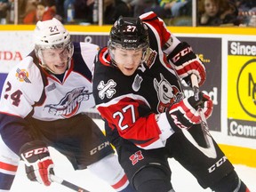 Cody Caron of the Niagara IceDogs and Graeme Brown of the Windsor Spitfires fight for the puck during OHL action in St. Catharines on Jan. 11, 2014. (Julie Jocsak/Postmedia Network)